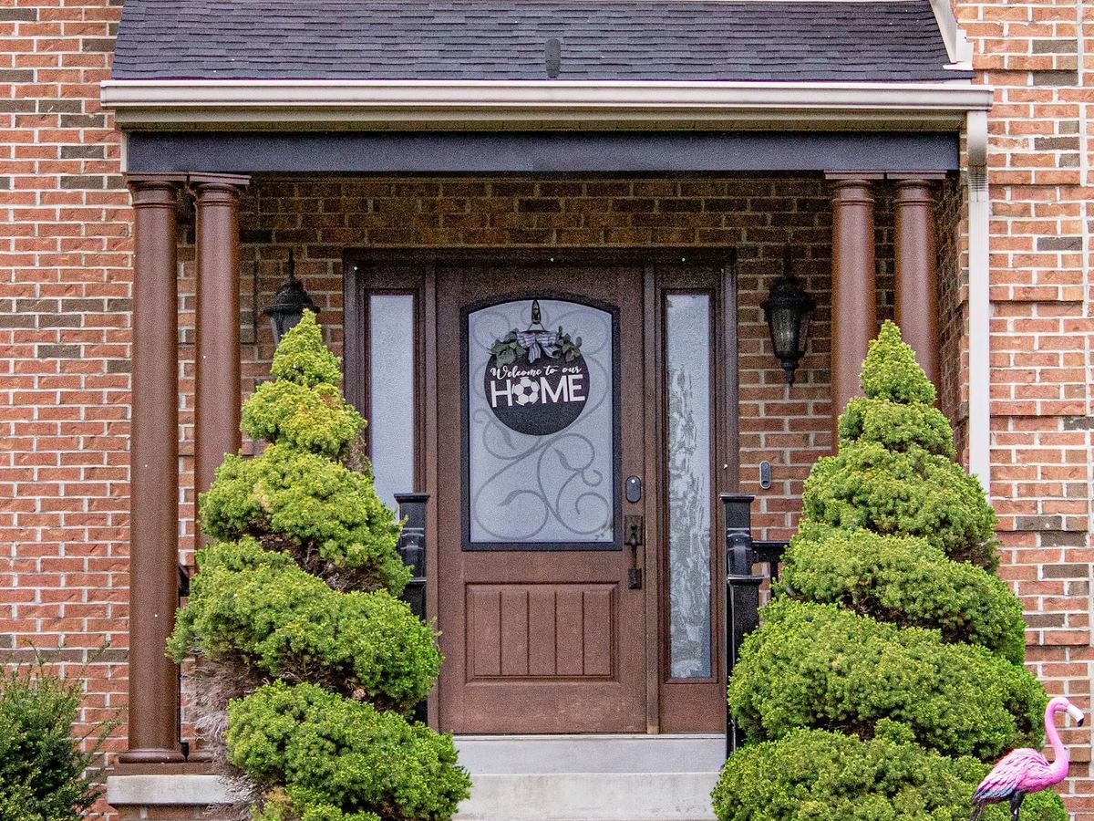 Brick home with a front door and tidy landscaping
